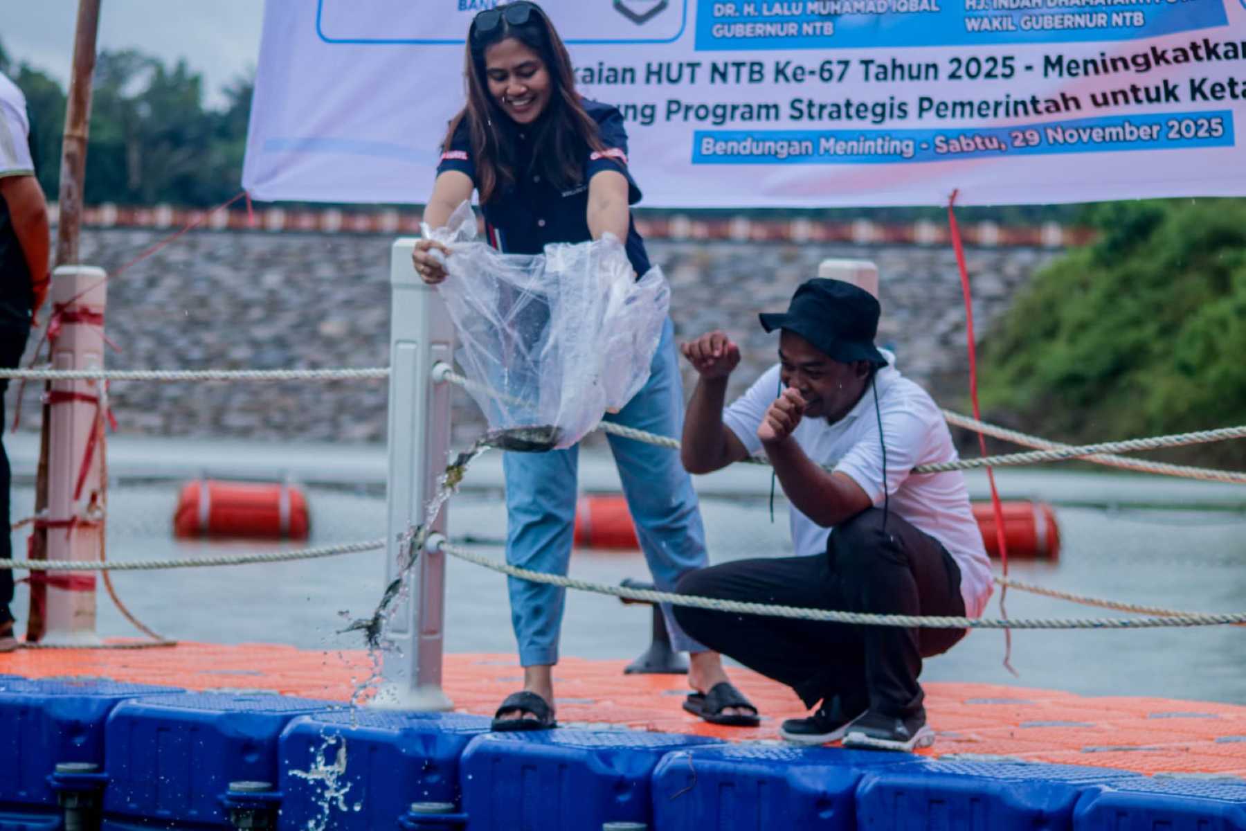 Perwakilan Astra Motor NTB, bersama salah seorang anggota FWE NTB, melepas bibit ikan di Bendungan Meninting, Kabupaten Lombok Barat.